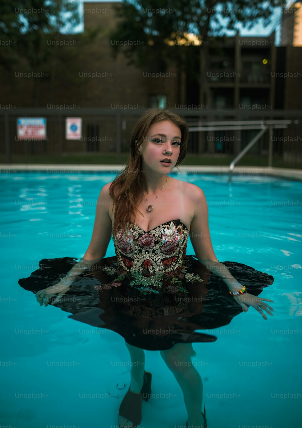 Una mujer parada en una piscina con las manos en el agua