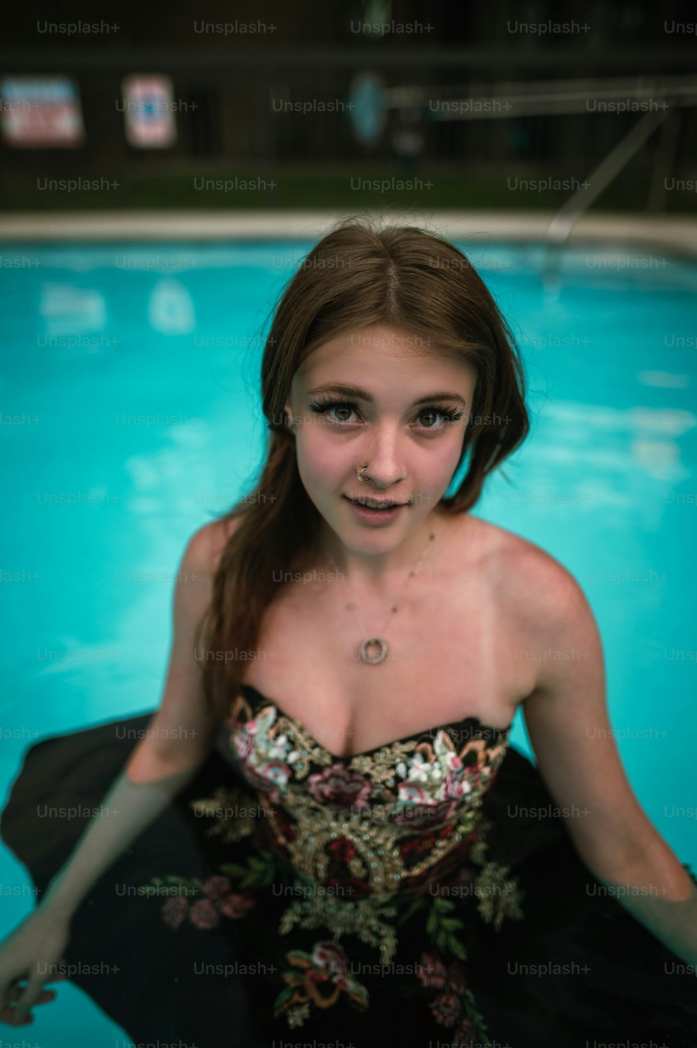 a woman in a black dress standing in a pool
