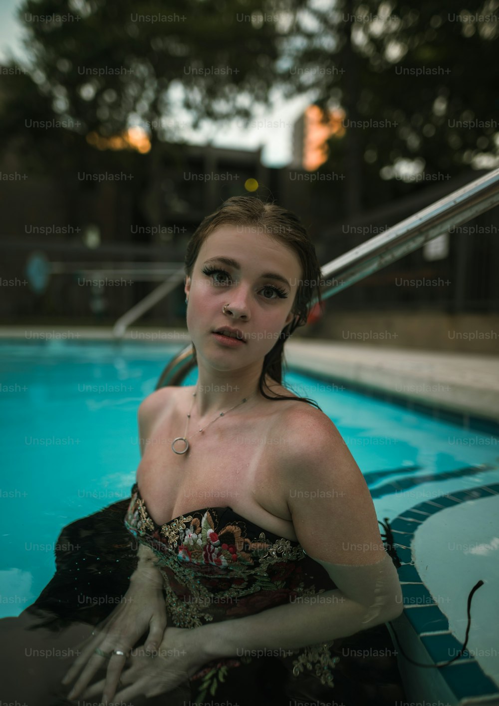 a woman in a dress sitting in a pool
