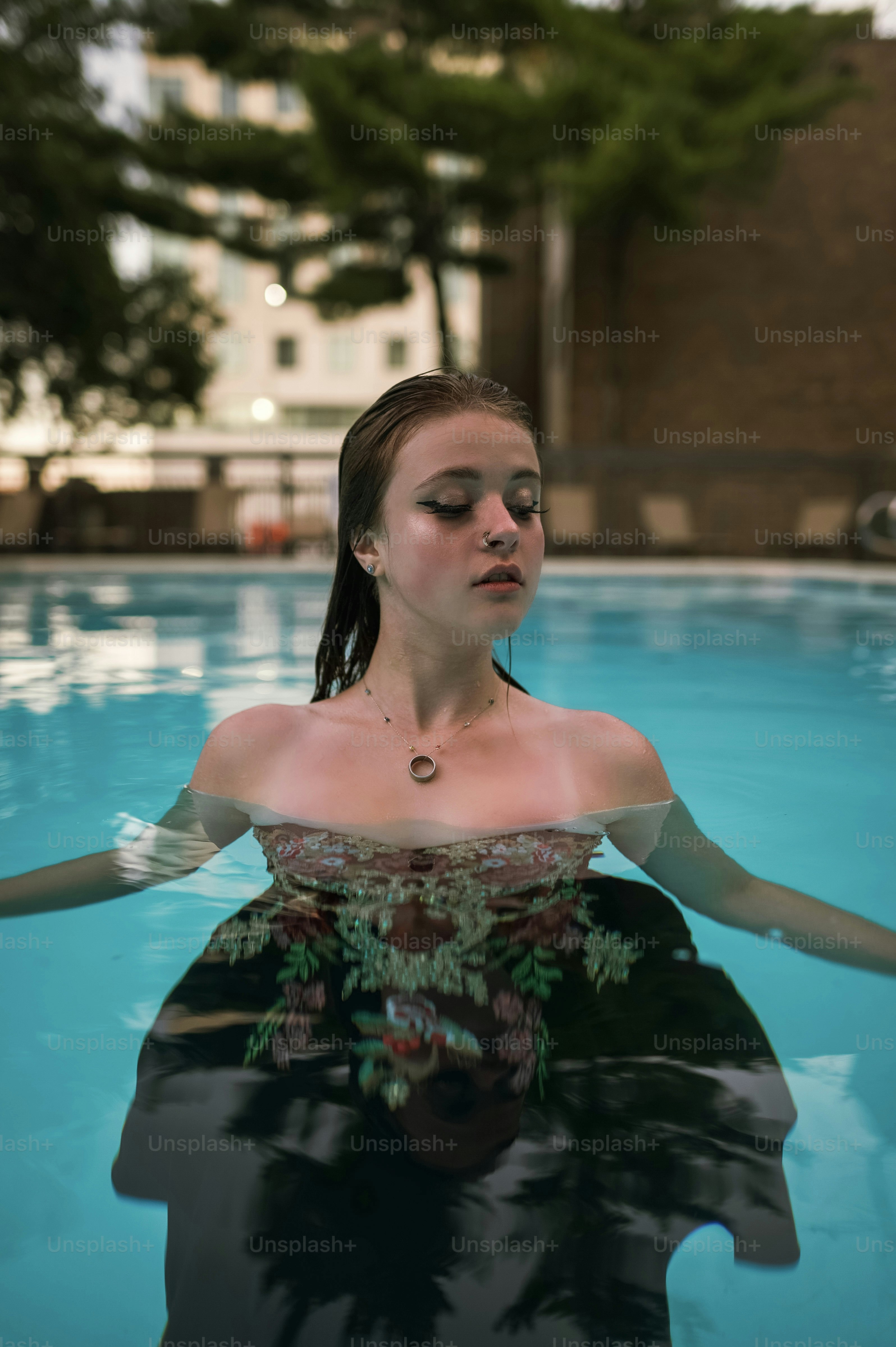 Eine Frau, die in einem Pool sitzt und ein Kleid trägt