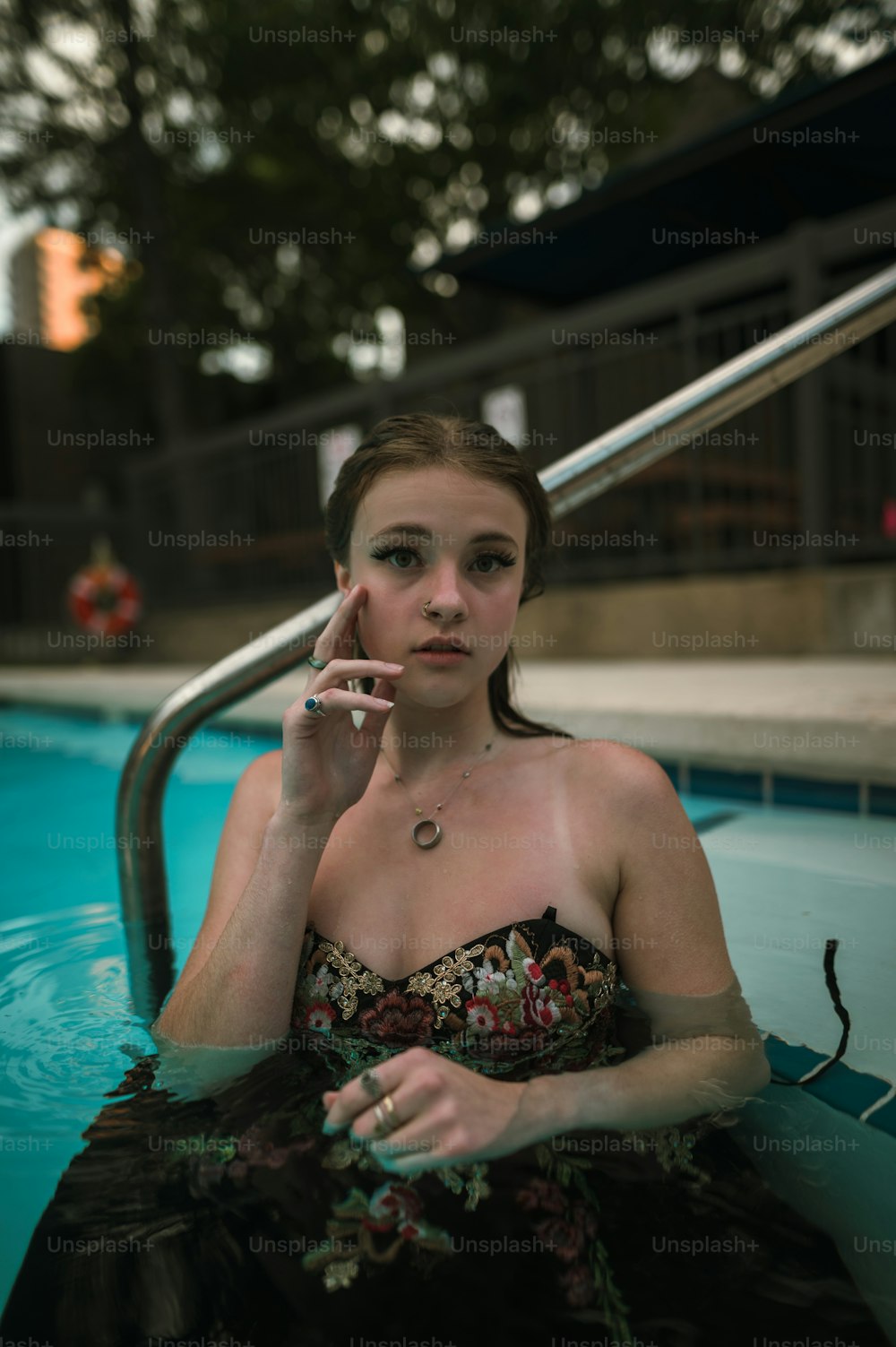 uma mulher sentada em uma piscina fumando um cigarro
