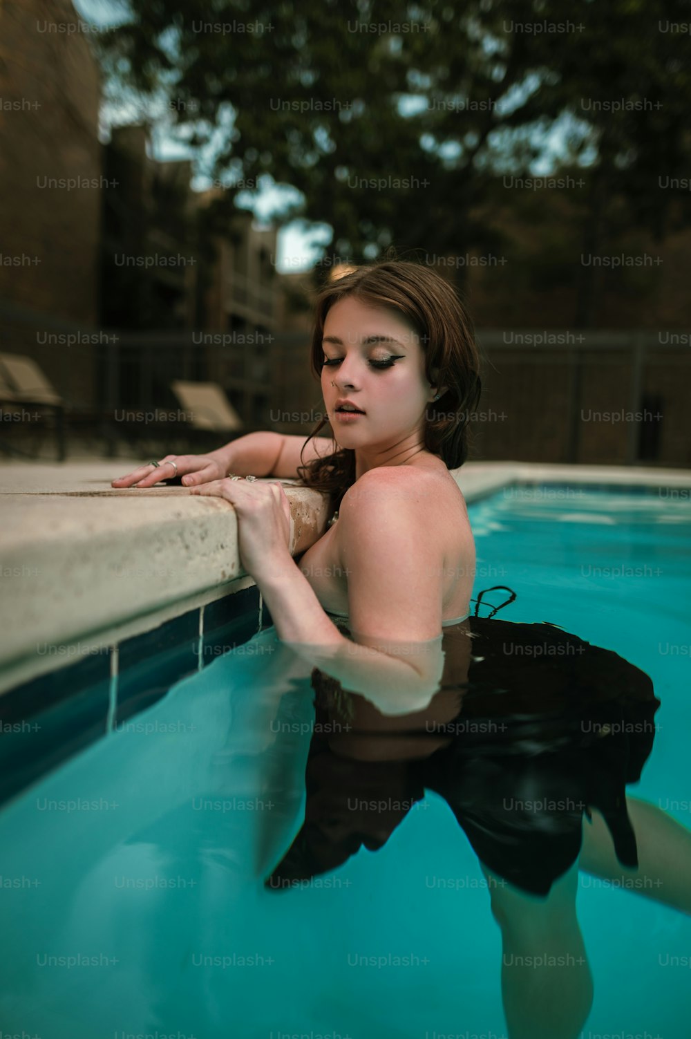 a woman in a black swimsuit is in a pool