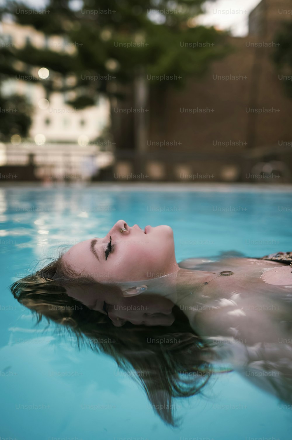 uma mulher flutuando em uma piscina de água