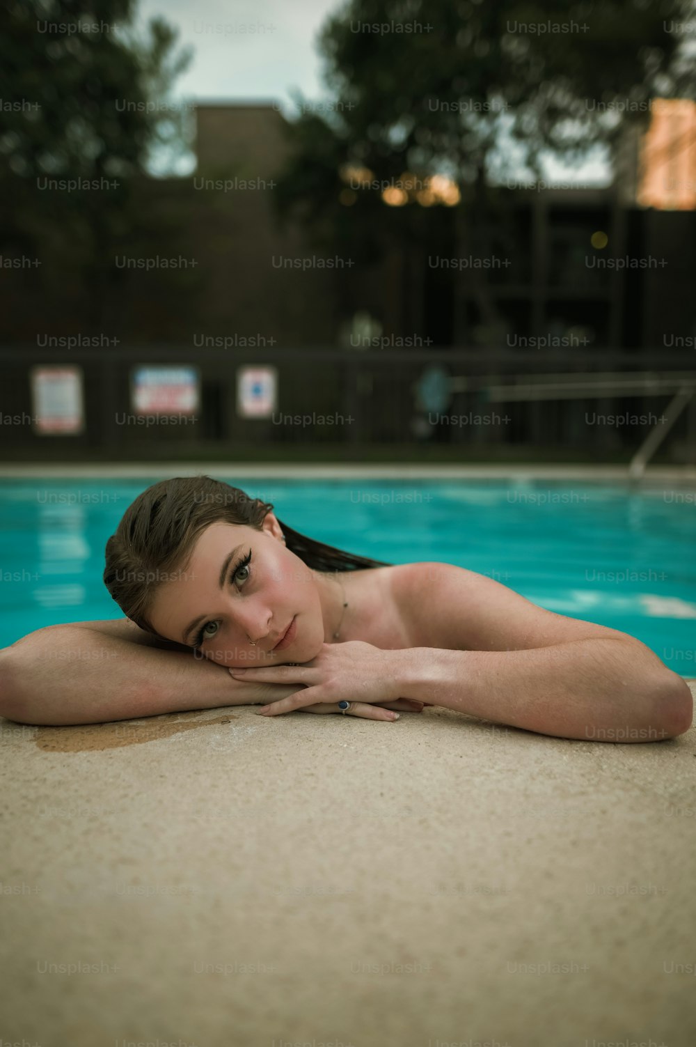 a beautiful young woman laying on top of a swimming pool
