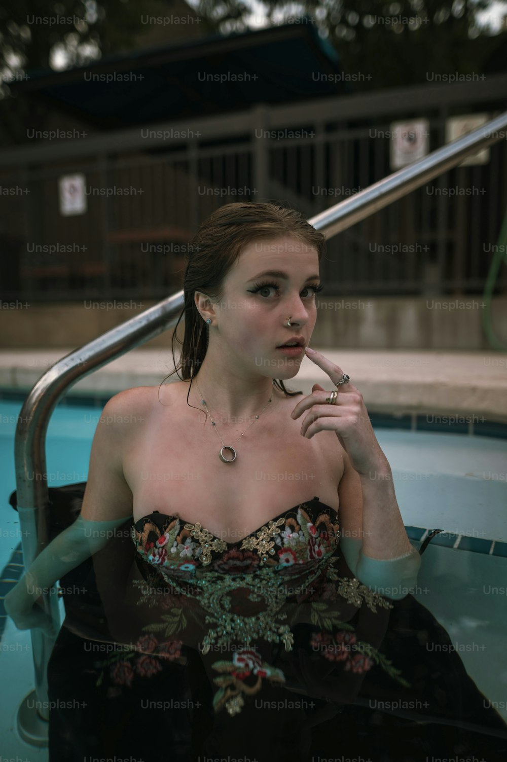 a woman sitting in a pool smoking a cigarette