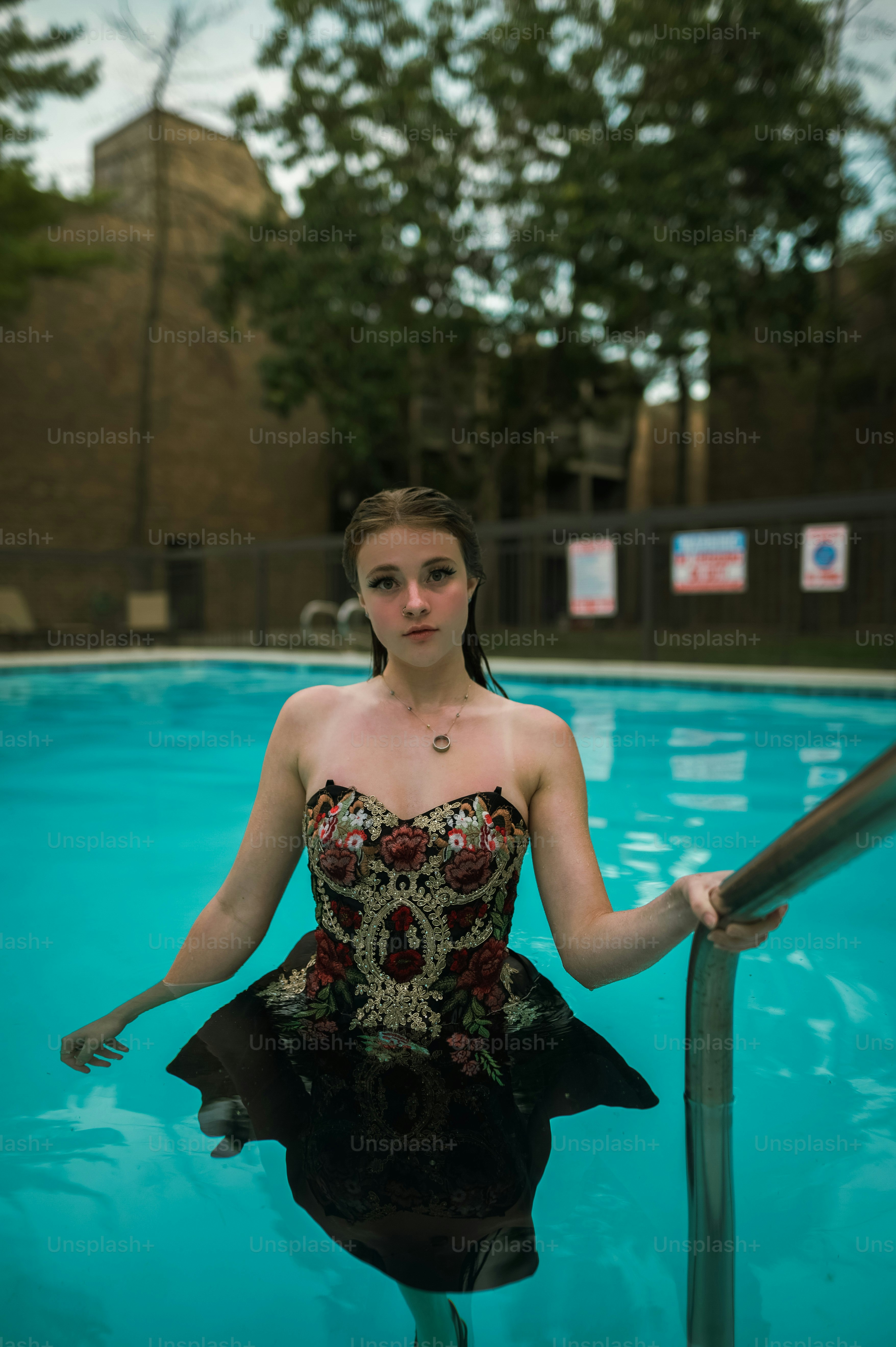 Foto zum Thema Eine Frau in einem Kleid, die in einem Pool steht – Bild ...