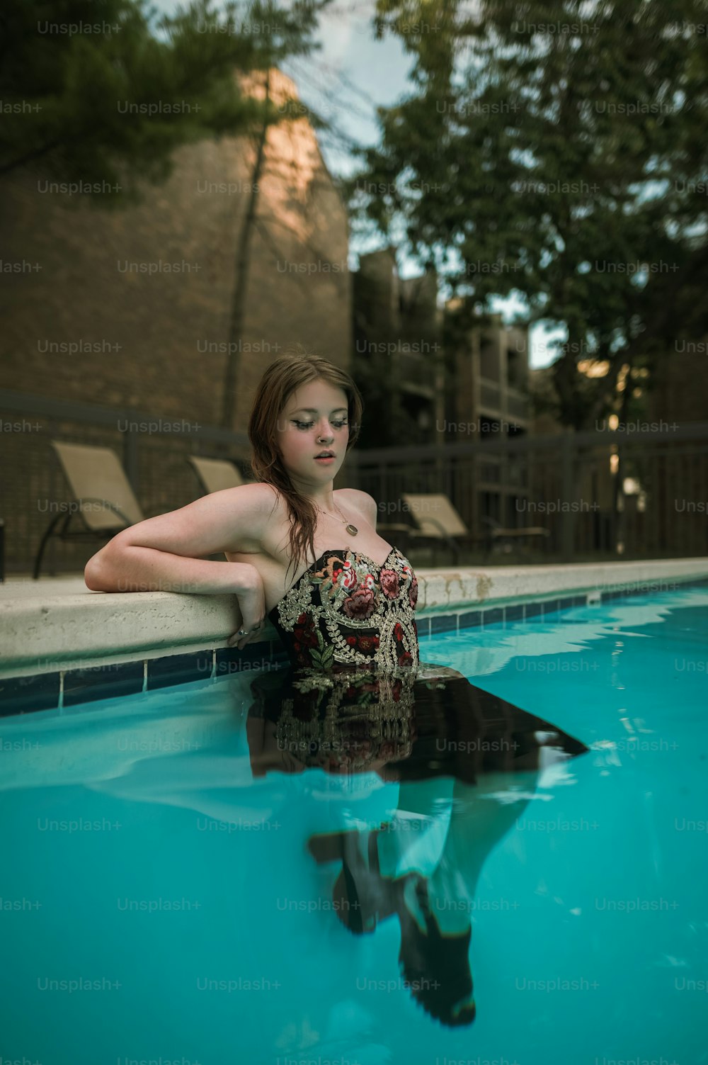 uma mulher em um maiô sentado em uma piscina