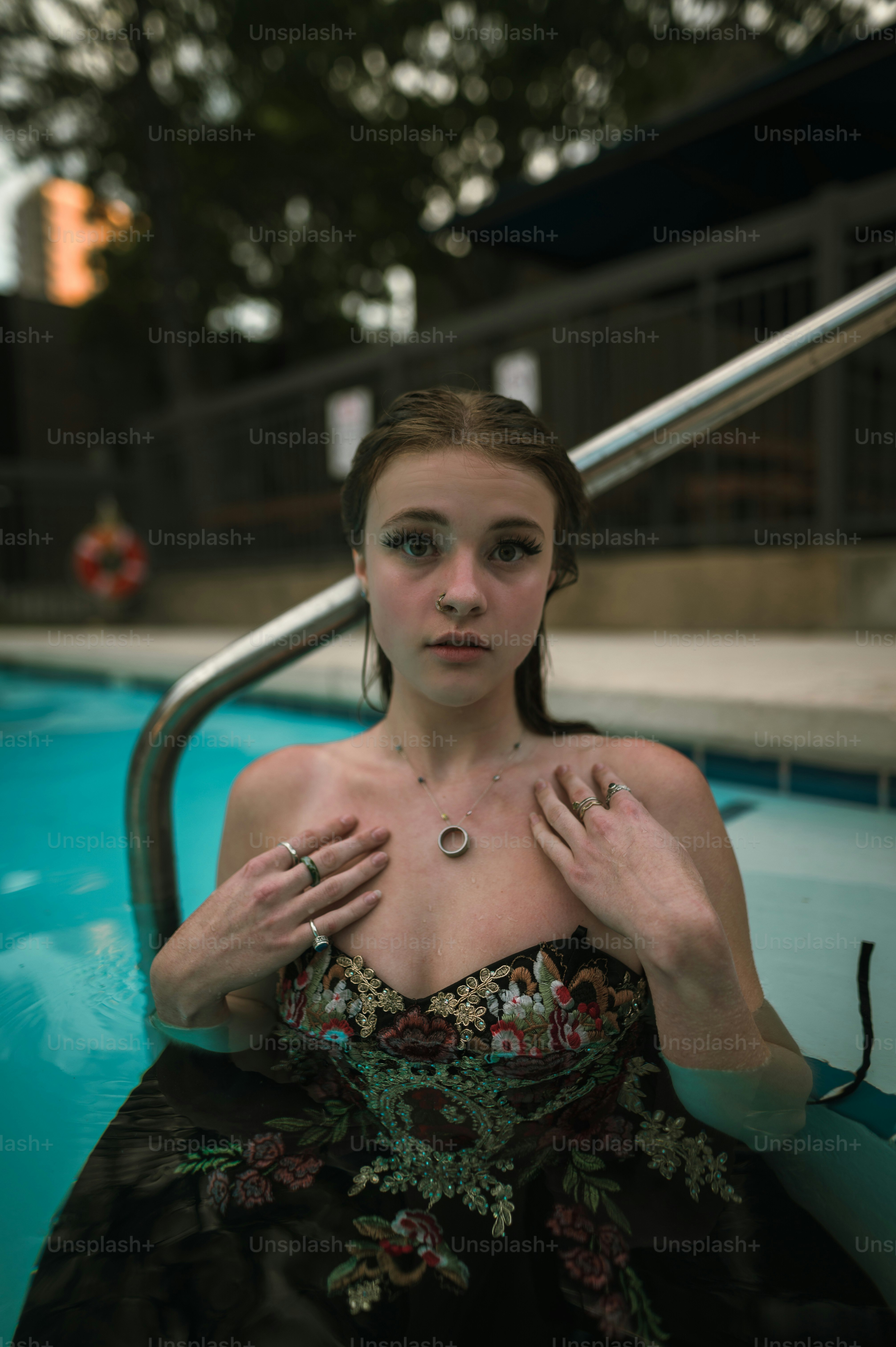 Eine Frau in einem schwarzen Kleid sitzt in einem Pool