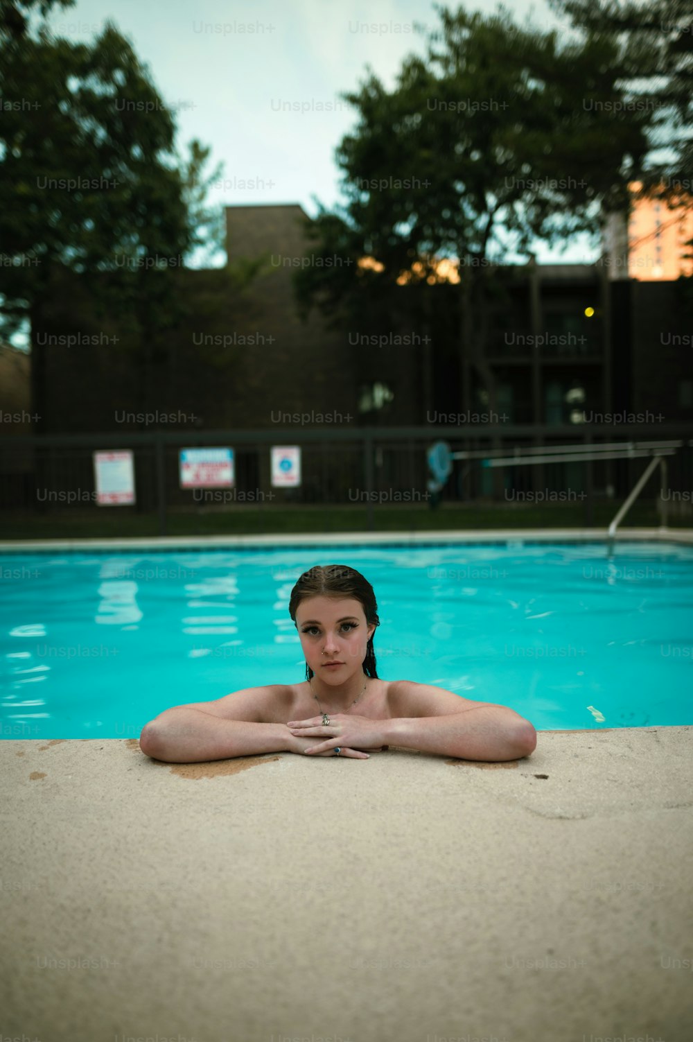 a woman sitting in front of a swimming pool