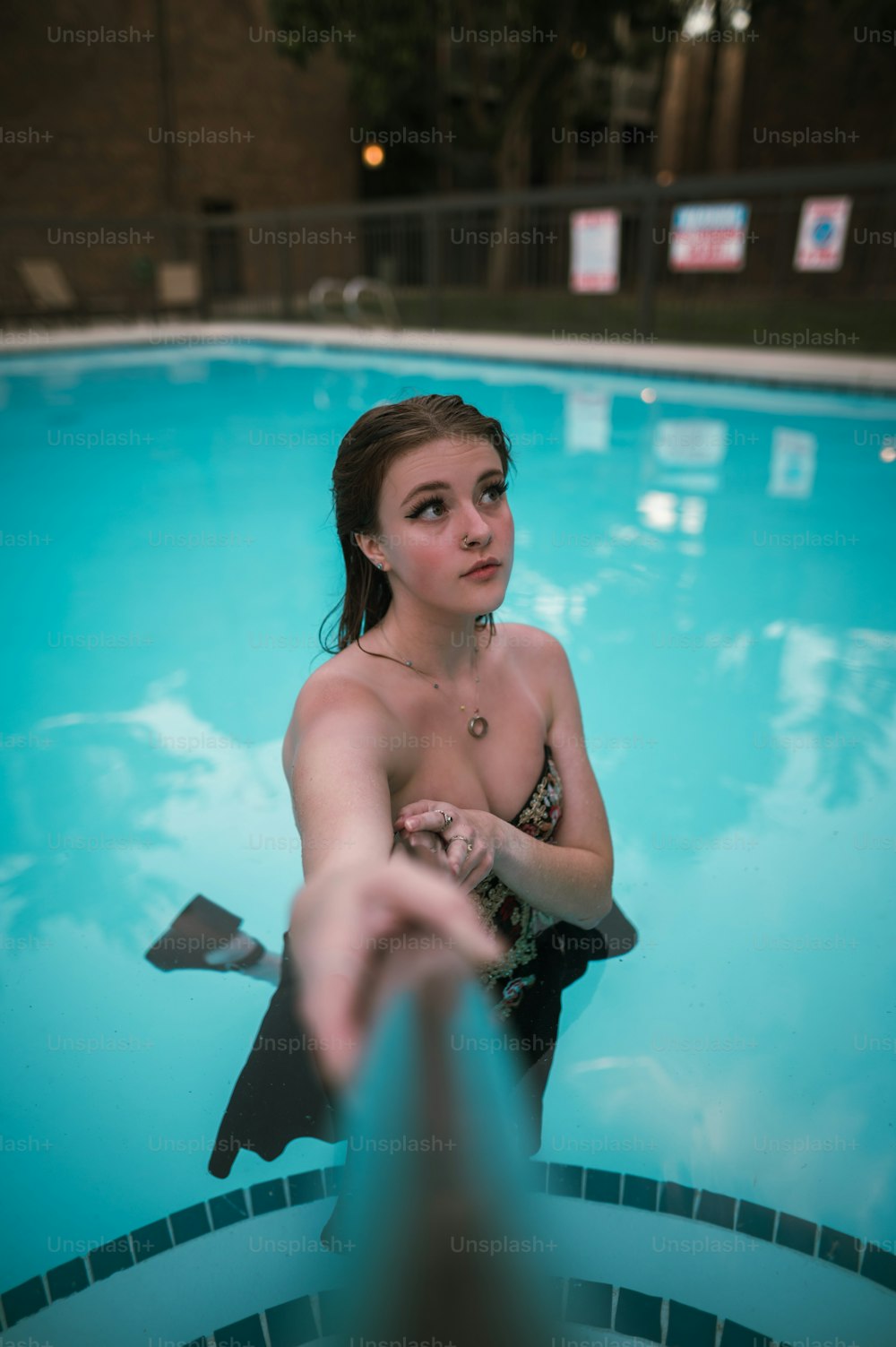 Una mujer en bikini parada en una piscina