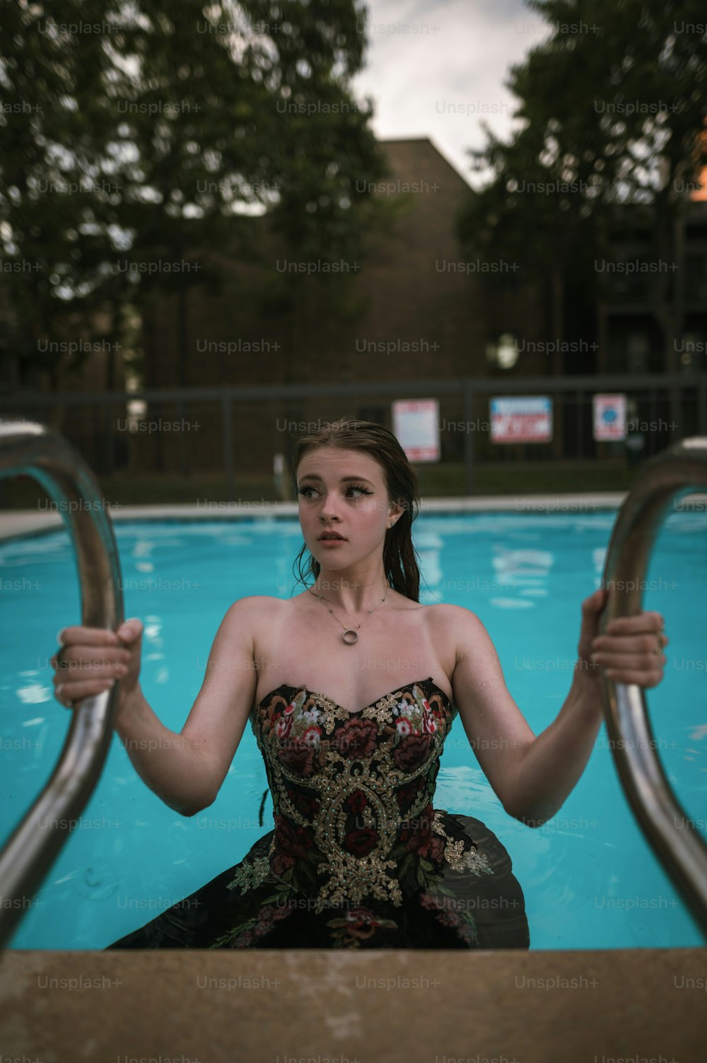 Una mujer con un vestido sentada en una piscina