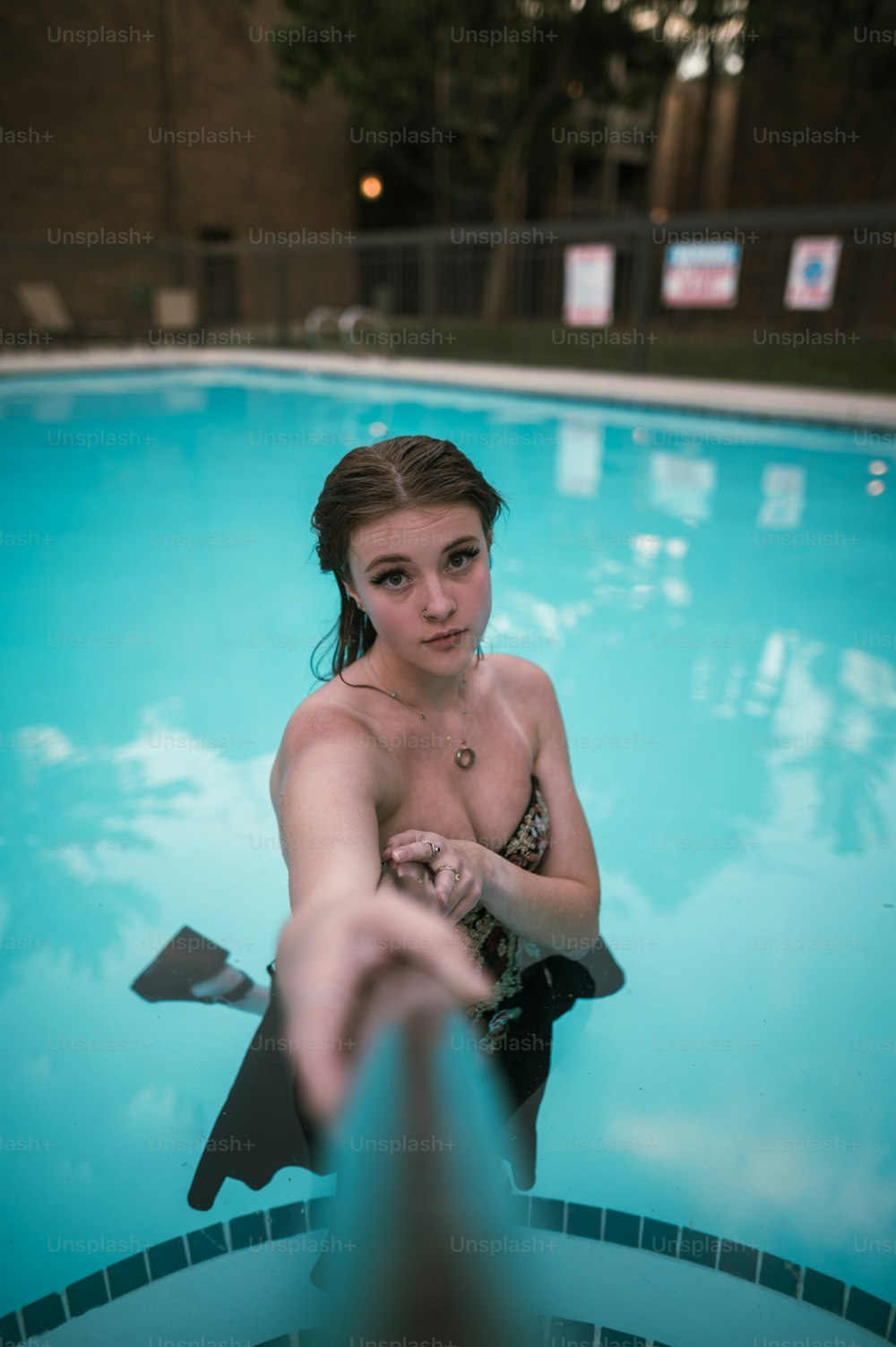 una donna in un costume da bagno in piedi in una piscina
