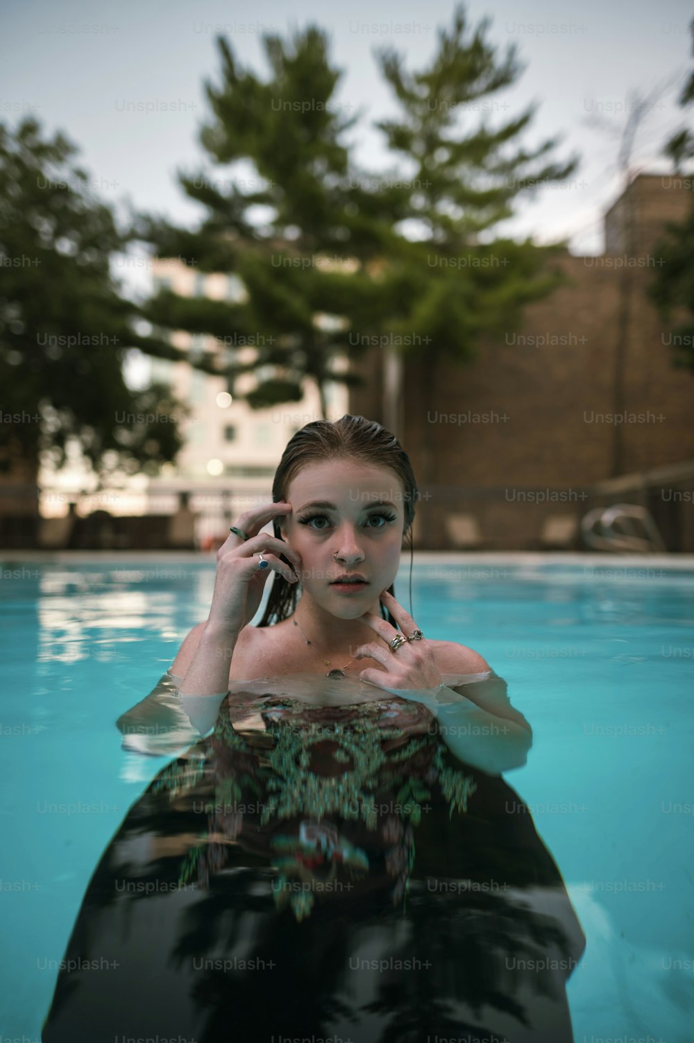 a woman in a pool talking on a cell phone