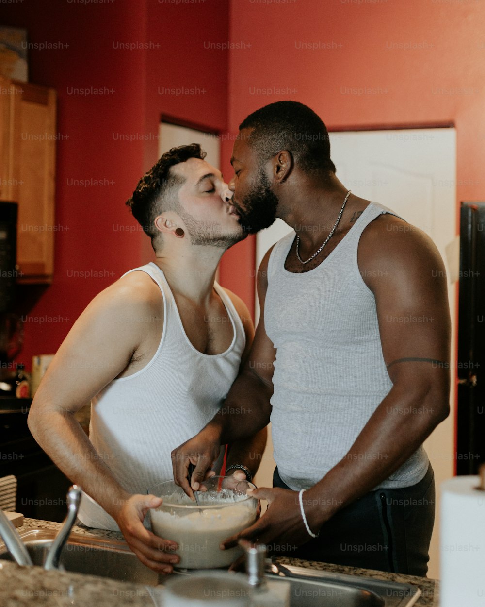 a couple of men standing next to each other in a kitchen