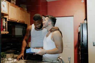 a couple of men standing in a kitchen next to each other