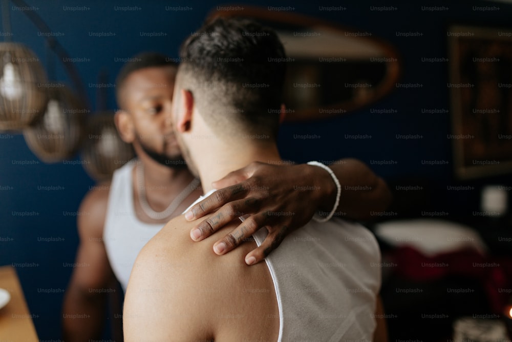 a man is hugging another man in a room