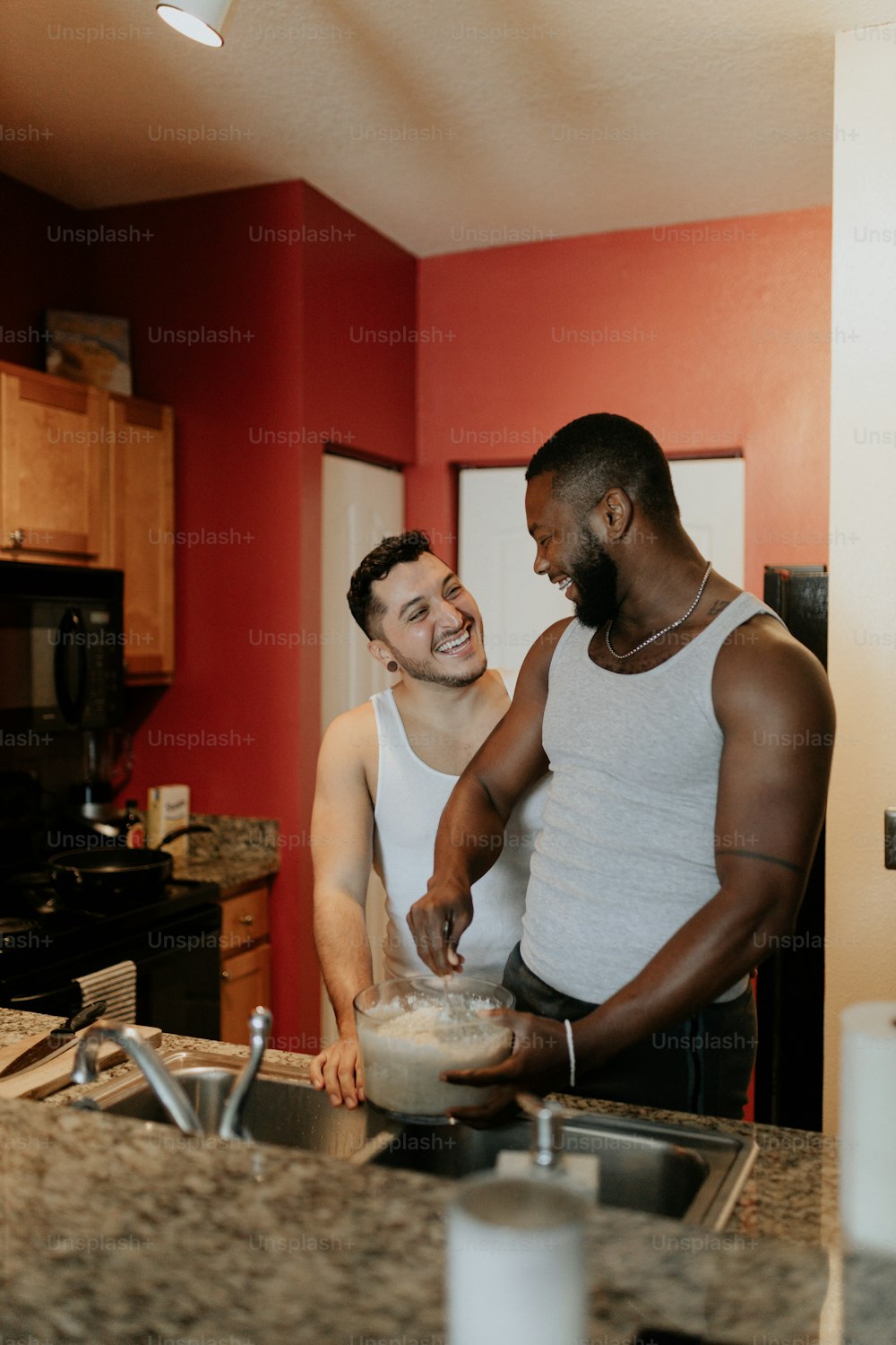 Un par de hombres parados en una cocina preparando comida