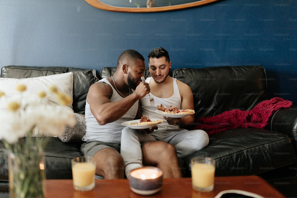 소파에 앉아 피자를 먹는 남자와 여자