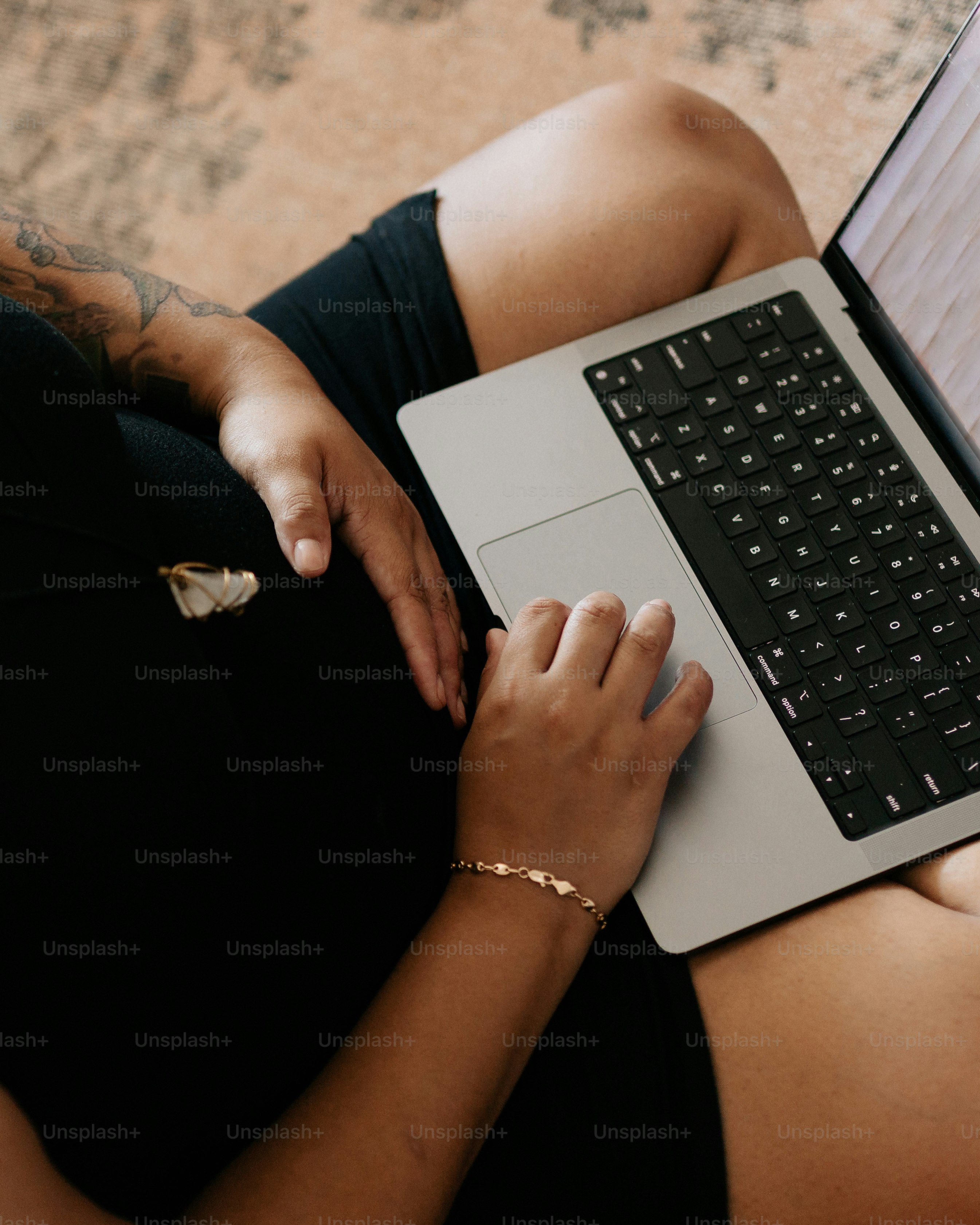 a woman sitting on the floor using a laptop computer