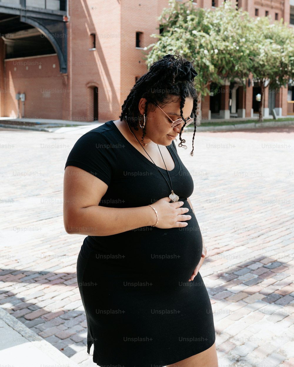 a pregnant woman in a short black dress
