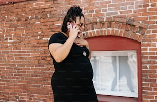 eine schwangere Frau, die mit einem Handy spricht