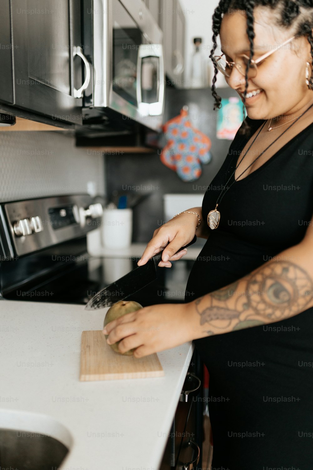 a woman standing in a kitchen cutting a apple