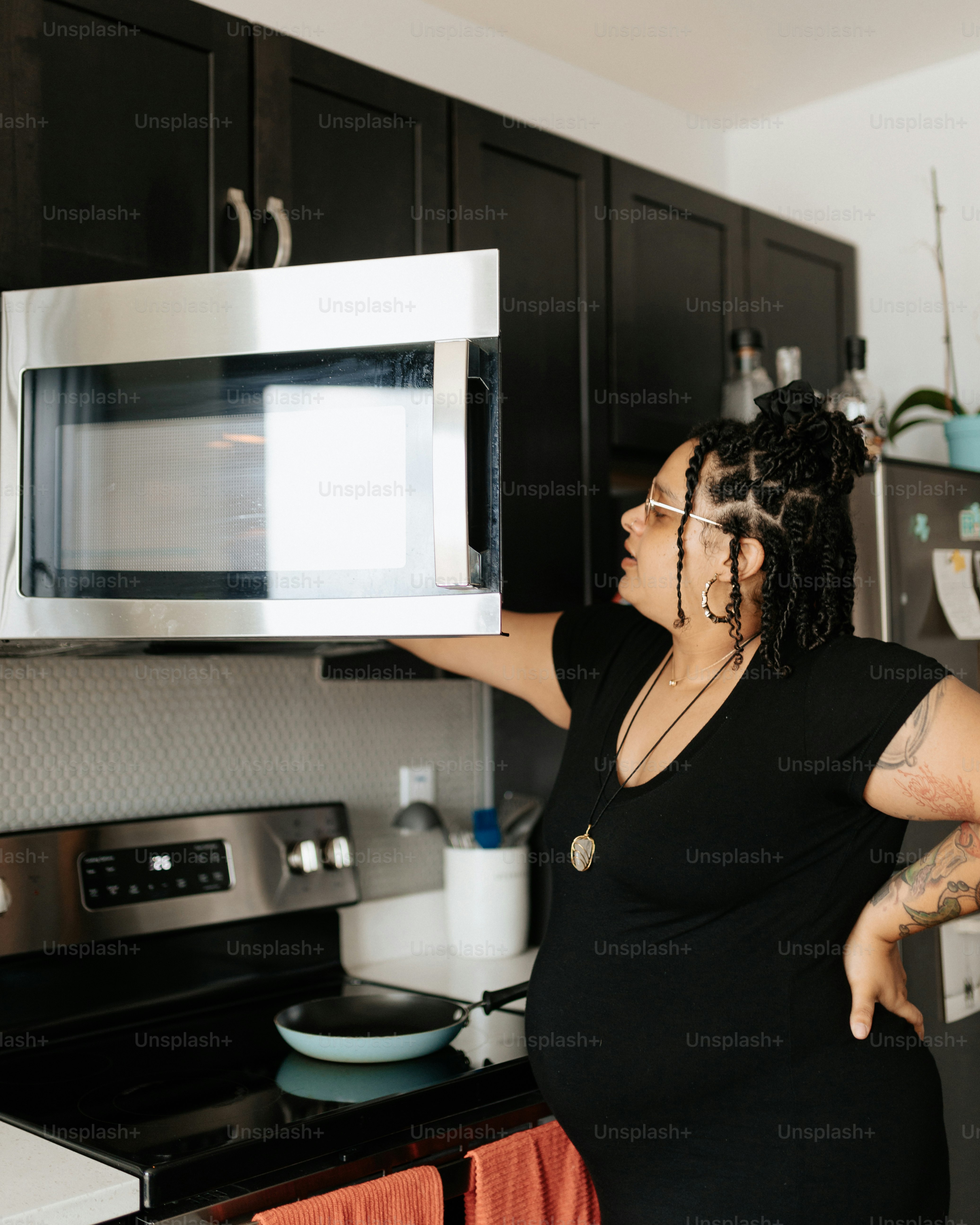 a woman holding a microwave over her face