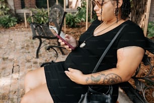 a woman sitting on a bench looking at her cell phone