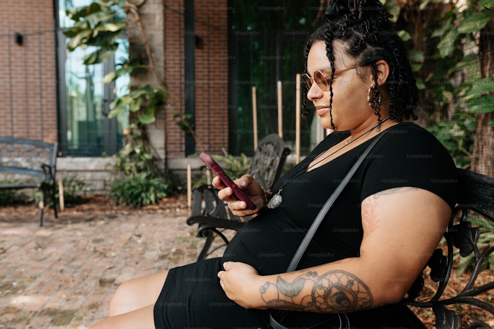 a woman sitting on a bench looking at her cell phone