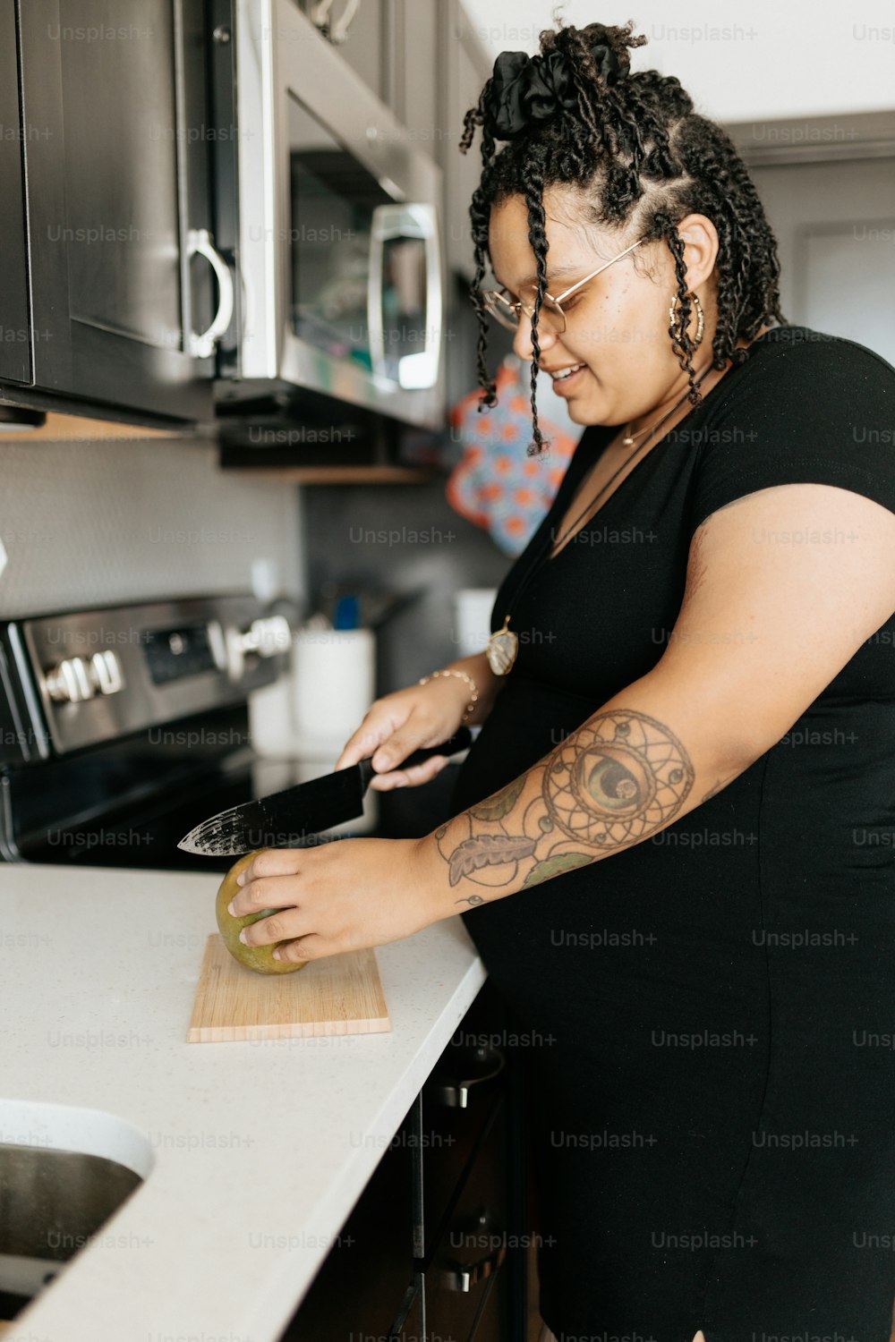 a woman standing in a kitchen cutting up food