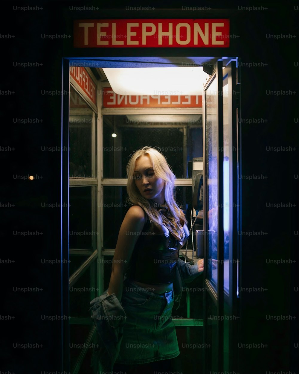 a woman is standing in a phone booth