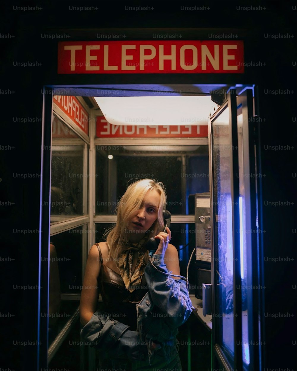 a woman talking on a cell phone in a booth