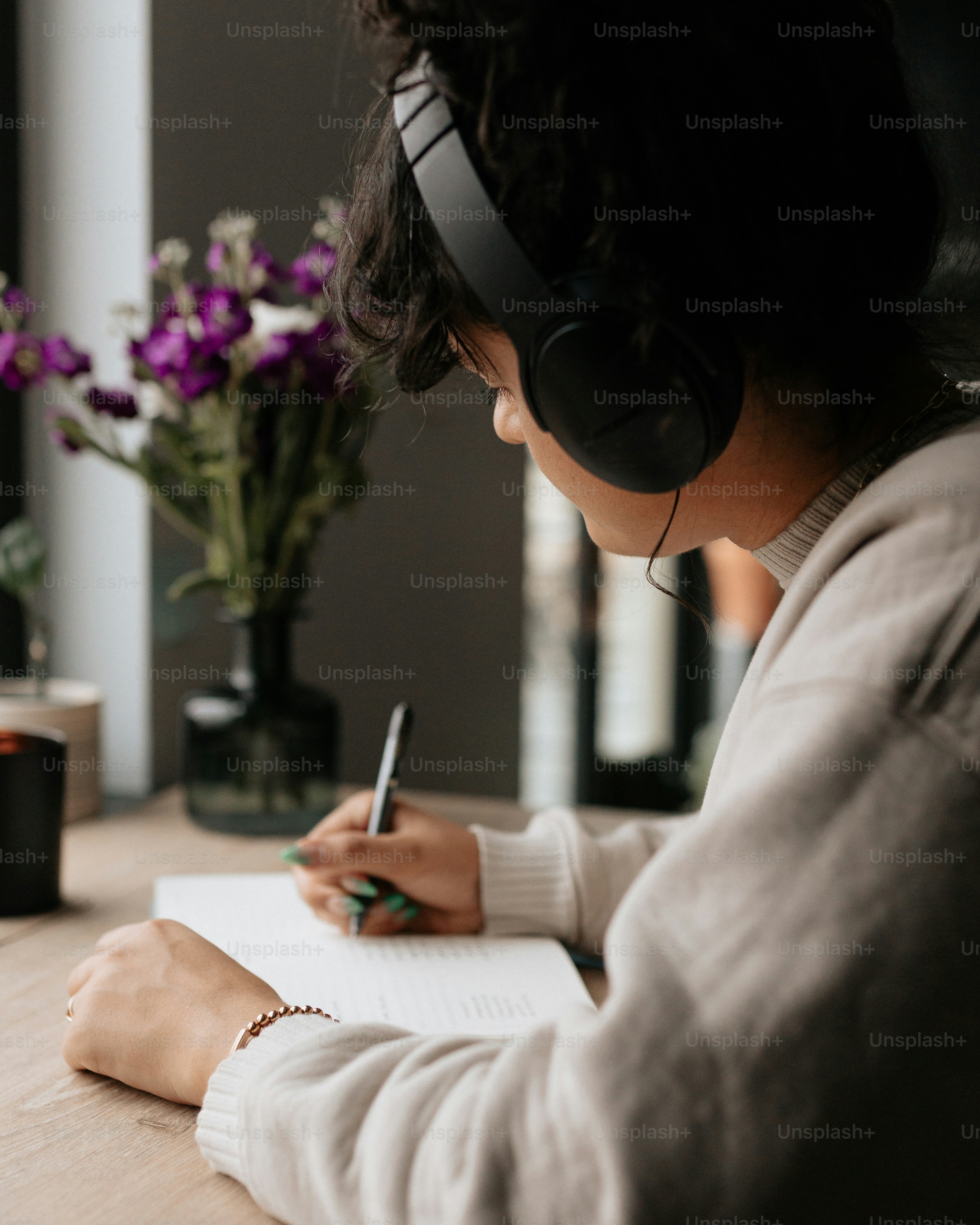 テーブルに座って紙に書く女性