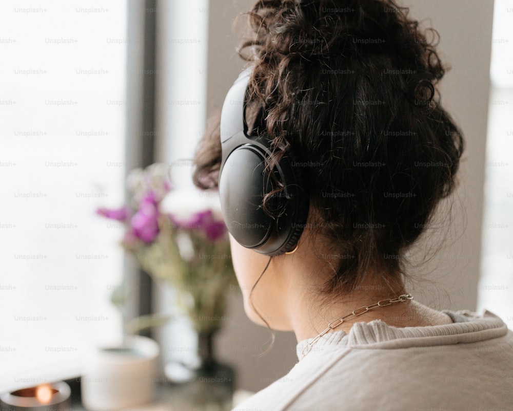 a woman wearing headphones looking out a window