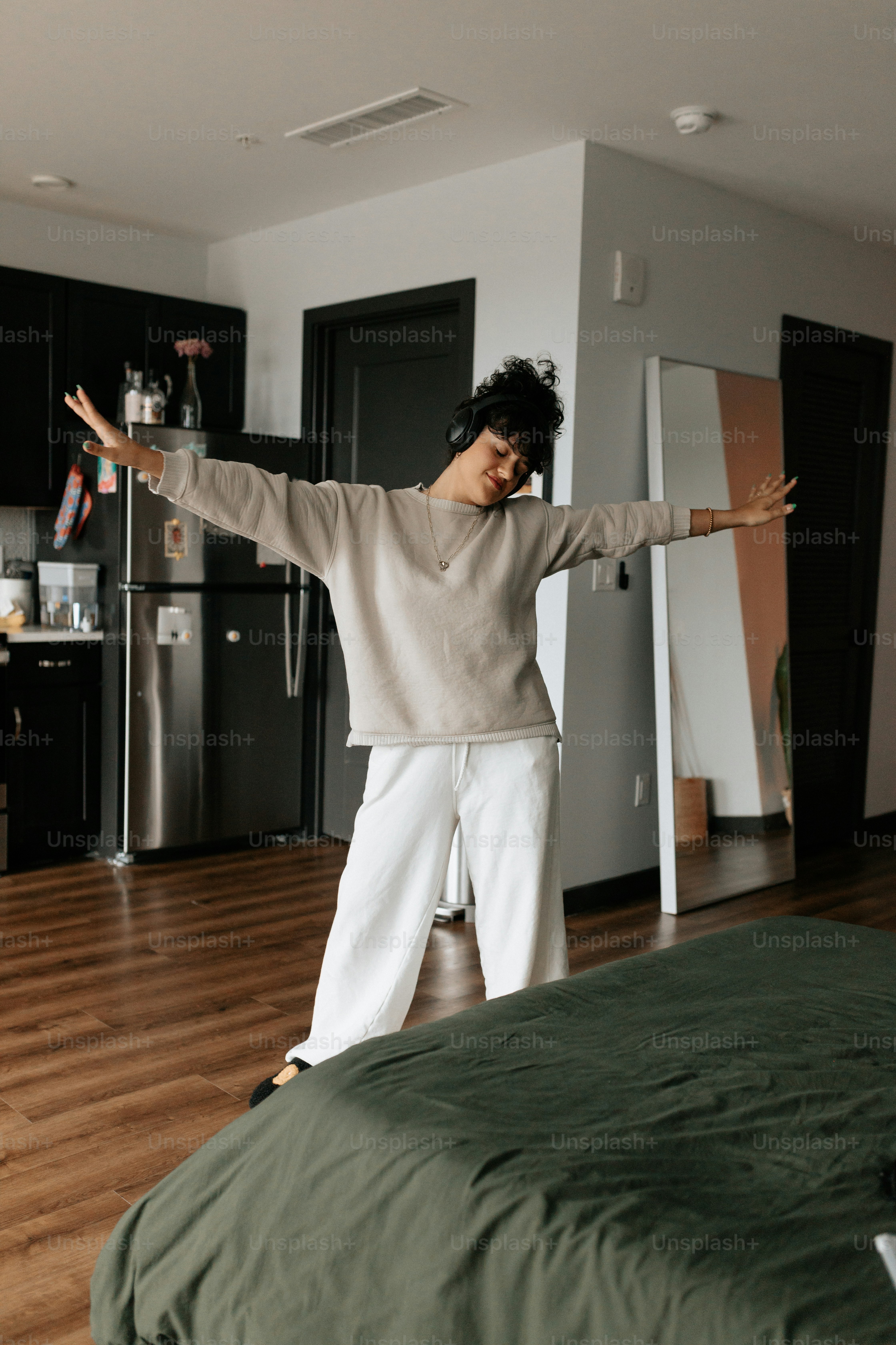 a woman standing on top of a bed in a room