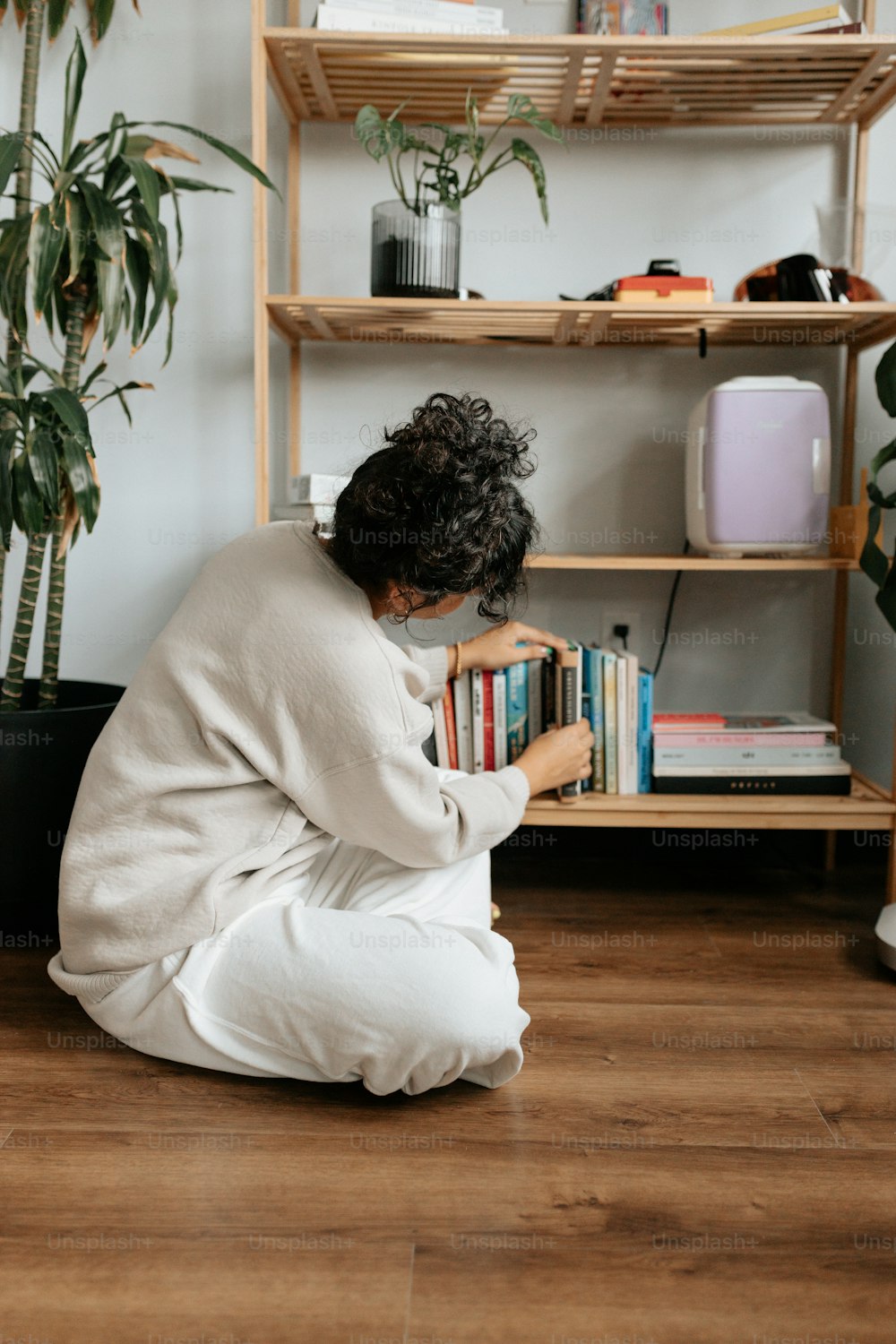 a woman sitting on the floor reading a book