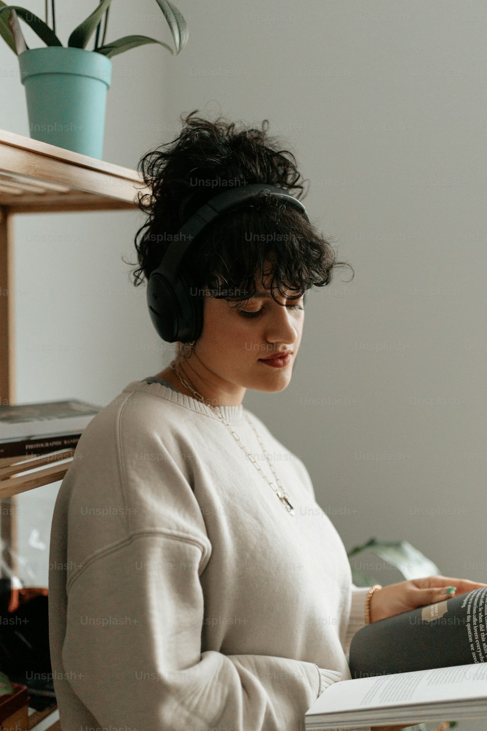 a woman wearing headphones and reading a book