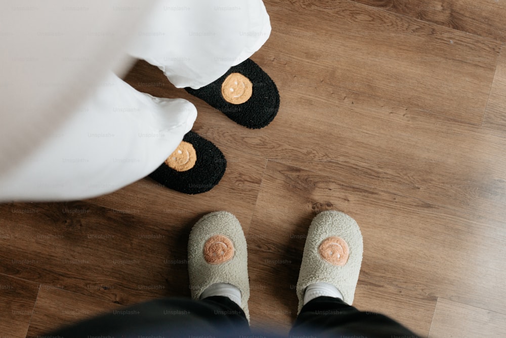 a person standing on a wooden floor wearing slippers