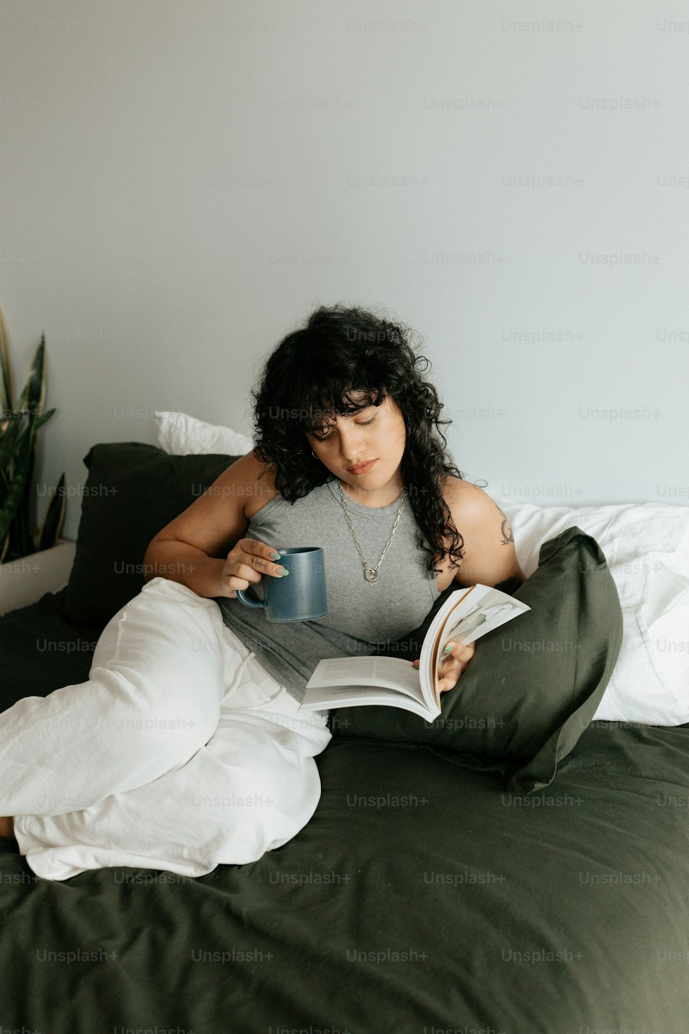 a woman laying on a bed reading a book