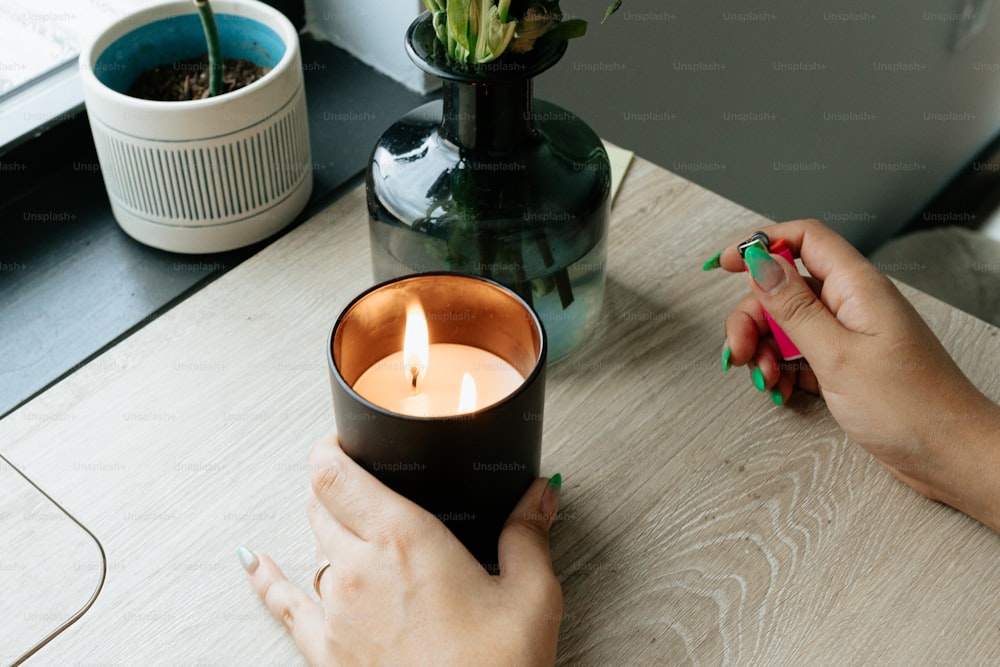 a woman is holding a candle on a table