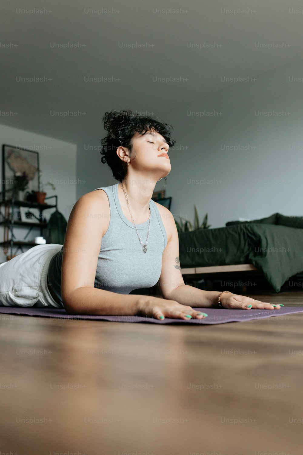 a woman sitting on a yoga mat in the middle of a room