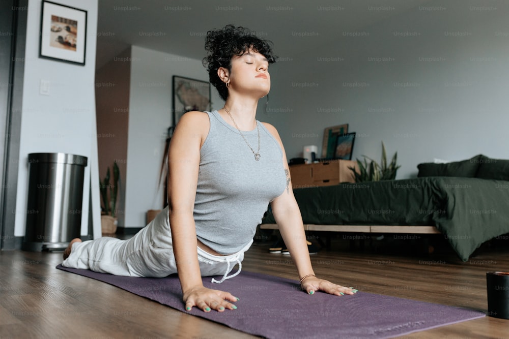 a woman sitting on a yoga mat in a room