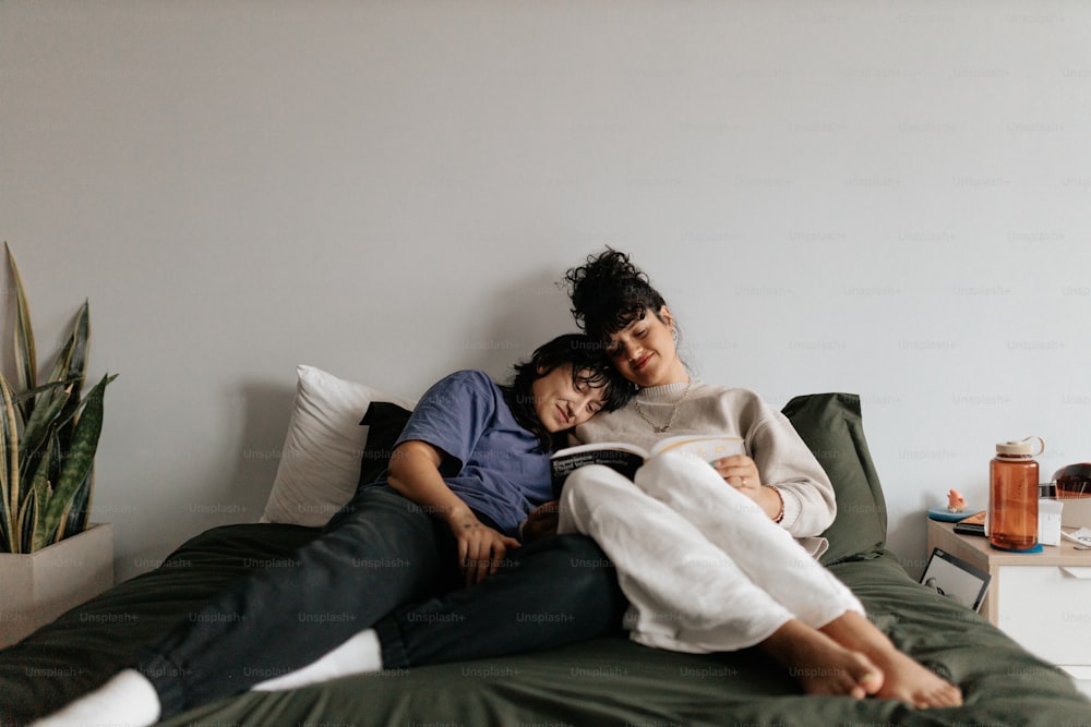 a couple of people laying on top of a bed