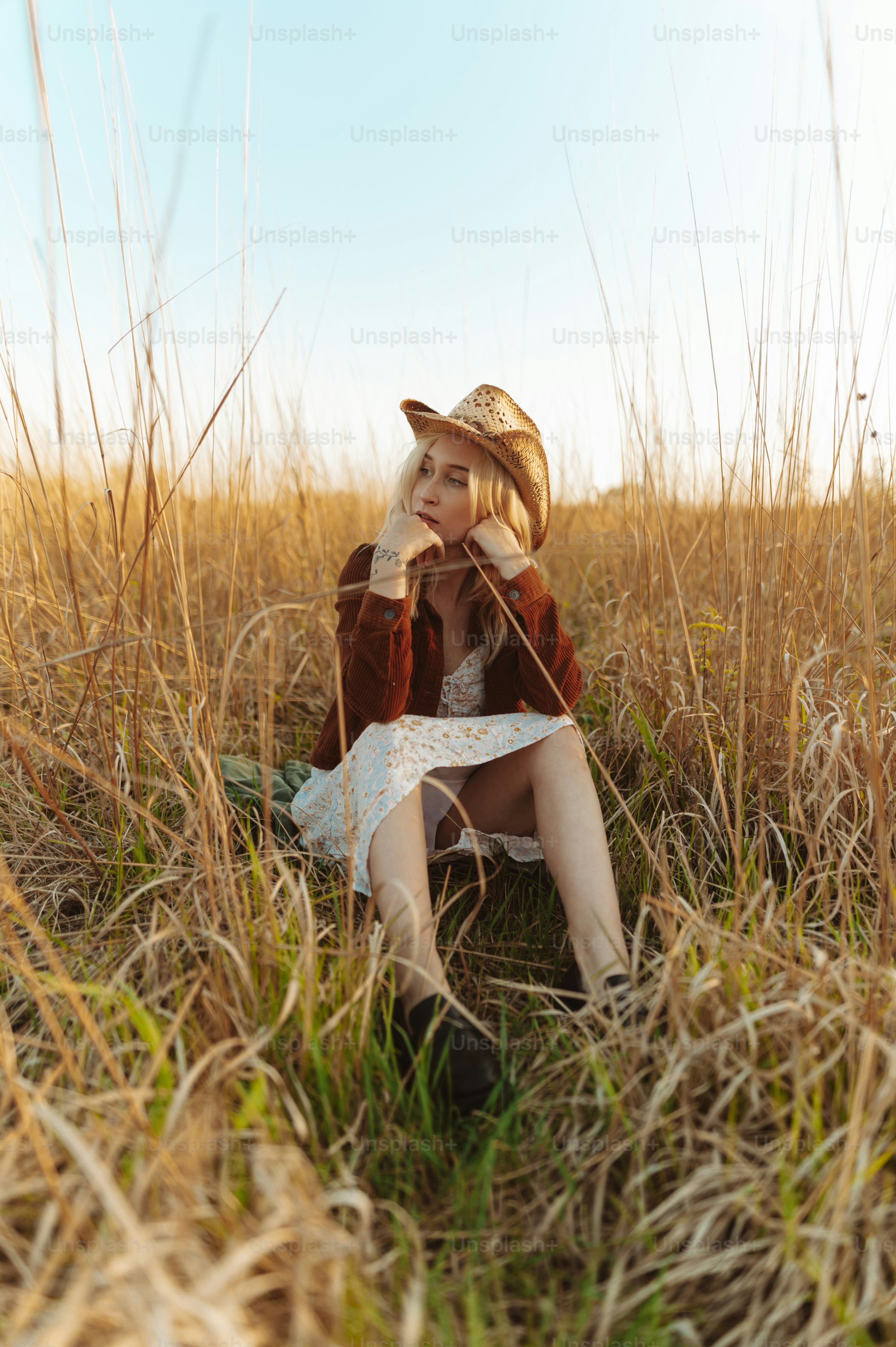 a woman sitting in a field of tall grass