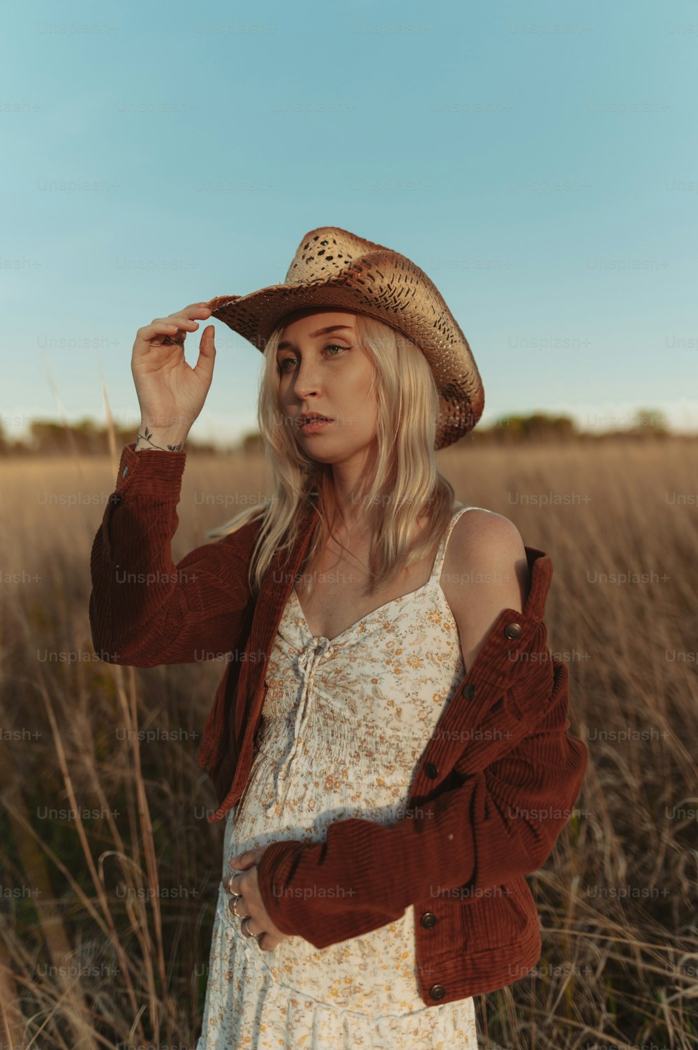 帽子をかぶって野原に立つ女性