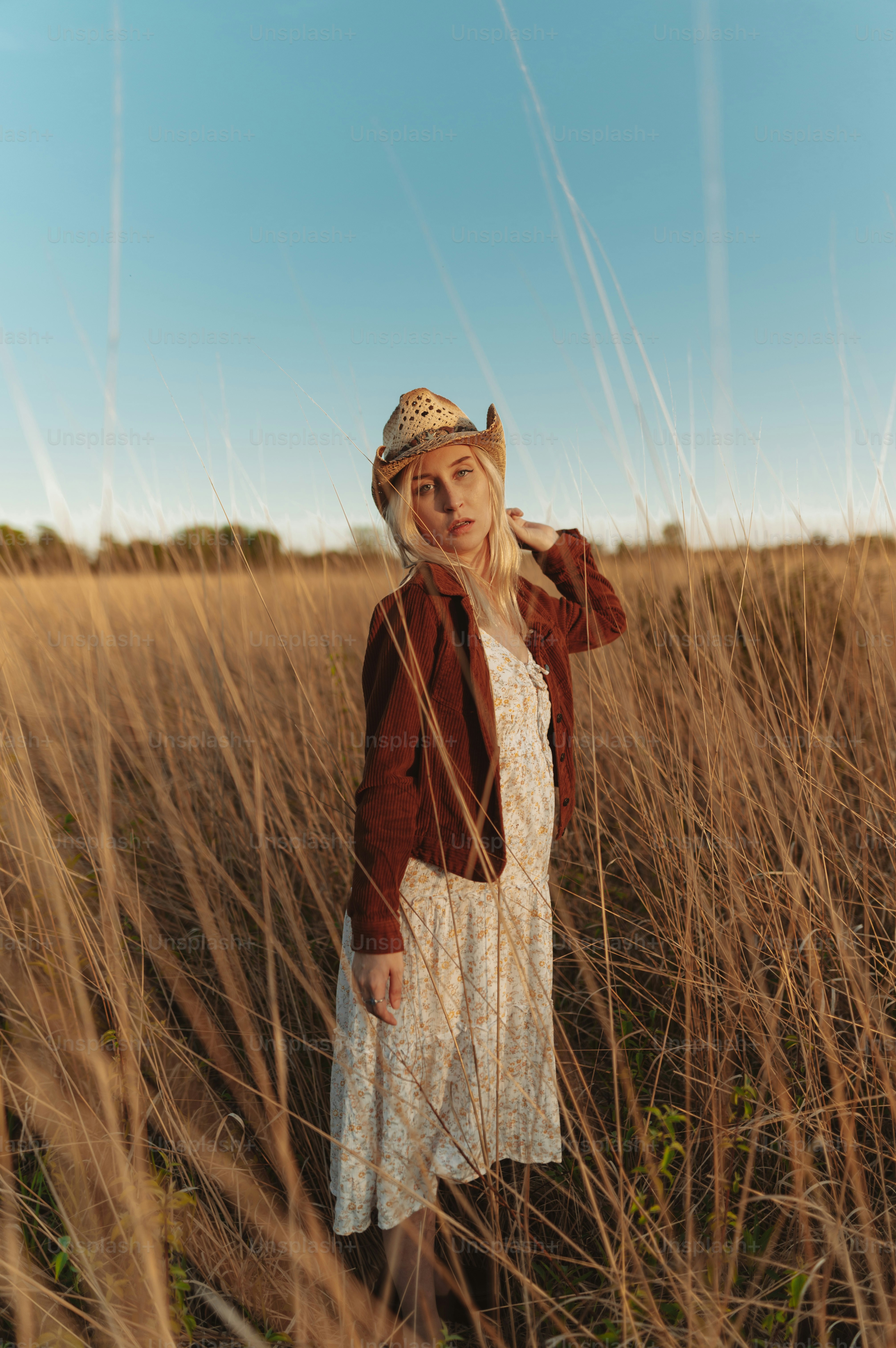 a woman standing in a field of tall grass