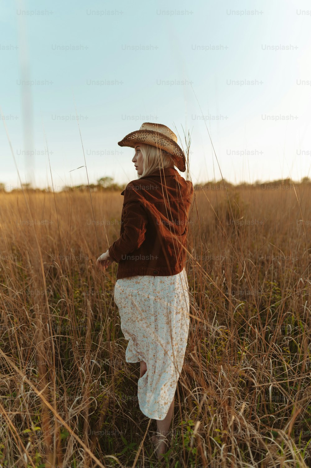 a woman standing in a field of tall grass