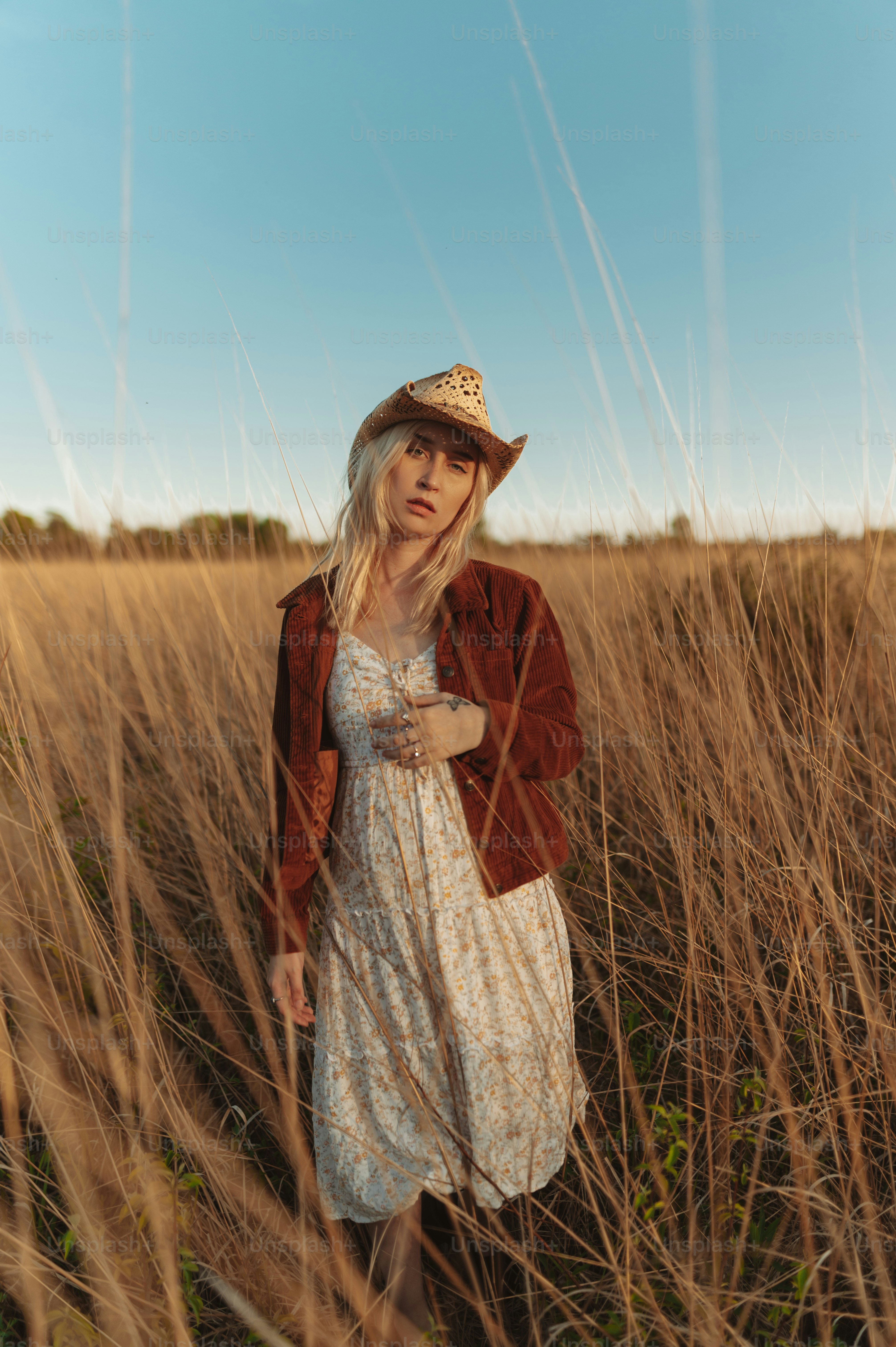 a woman standing in a field of tall grass