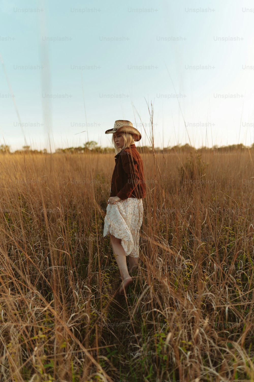 Una bambina che cammina attraverso un campo di erba alta