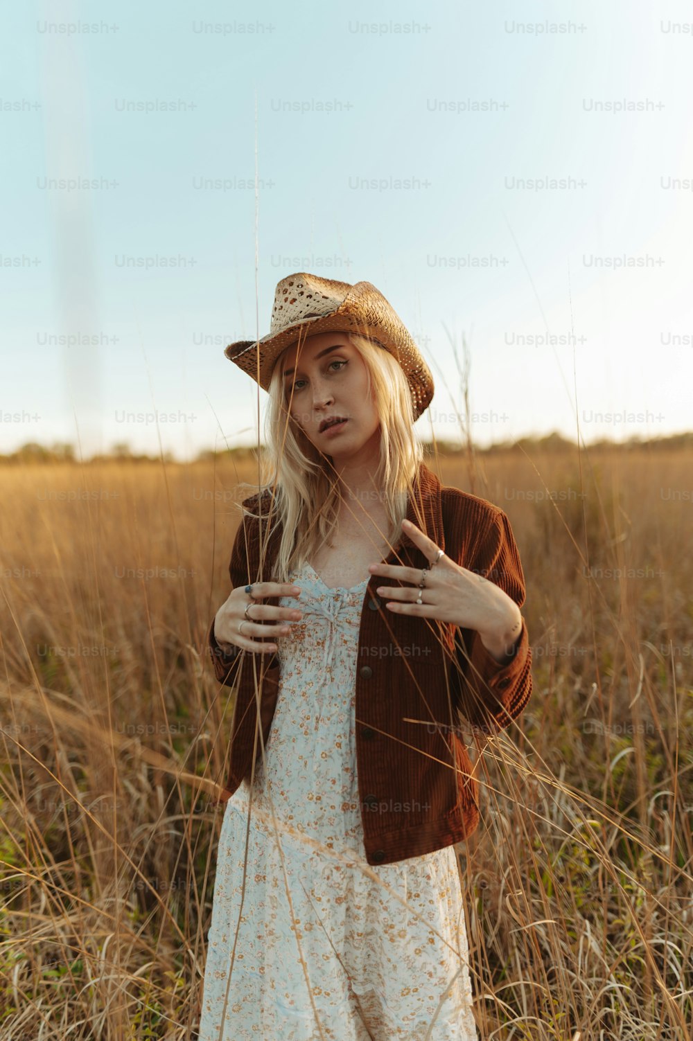 Una donna in piedi in un campo che indossa un cappello